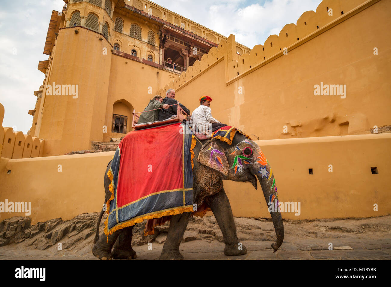 Amer Fort Jaipur with tourists enjoying decorated elephant ride. Amber