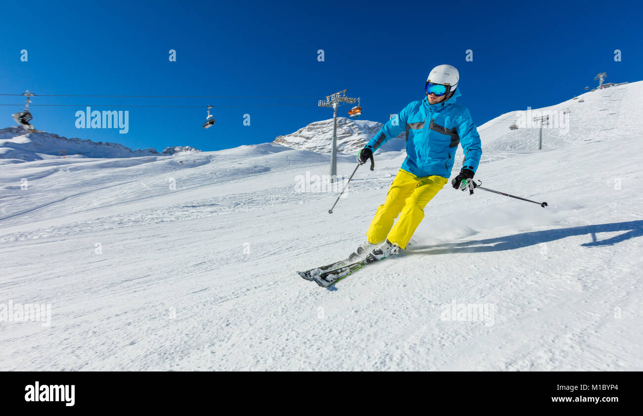 young-man-skiing-downhill-in-alps-beautiful-clear-blue-sky-winter