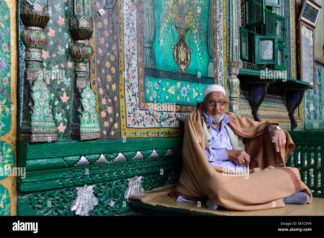 SRINAGAR, JAMMU AND KASHMIR, INDIA - 20 JUNE 2017: Muslim Imam welcoming faithful before the entry to a green uniquely wooden mosque, Shah E Hamdan Stock Photo
