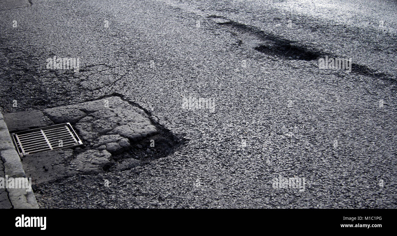 Damaged road, potholes, Glasgow, Scotland, UK Stock Photo