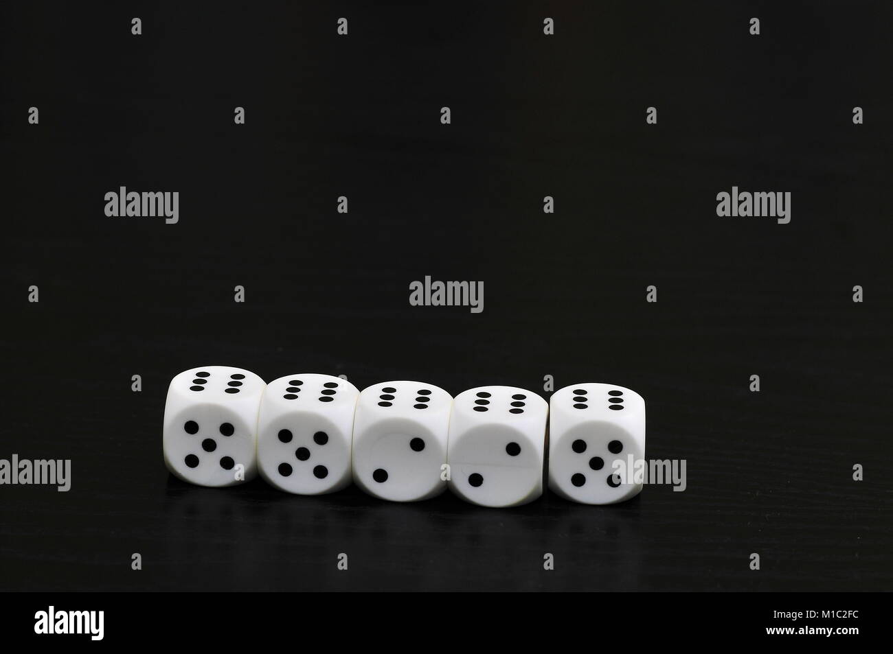 Five white dice on black table showing full house Stock Photo Alamy
