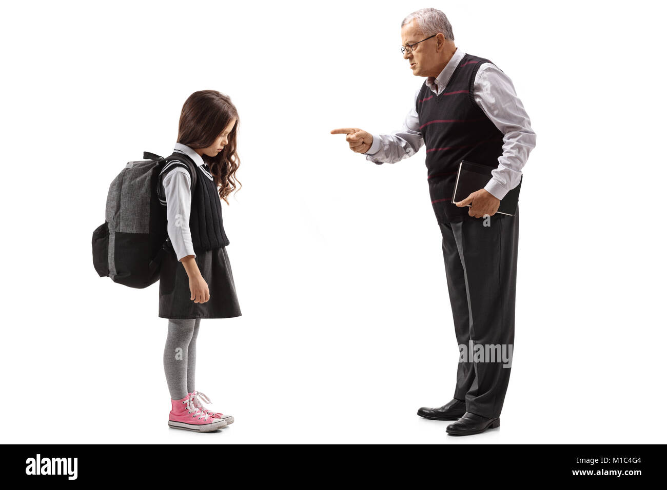 Full length profile shot of an old teacher scolding a schoolgirl isolated on white background Stock Photo