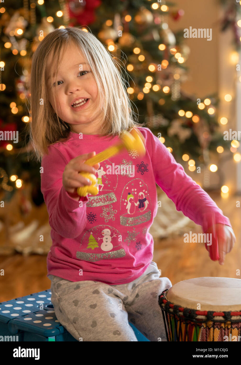 Young girl playing an african drum with small pieces of rope  Stock Photo