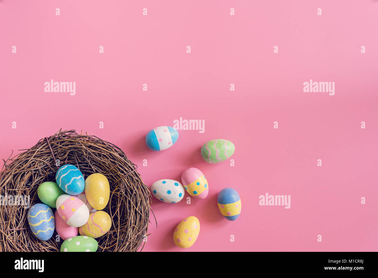 Colorful easter eggs in nest on pink pastel color background with space ...