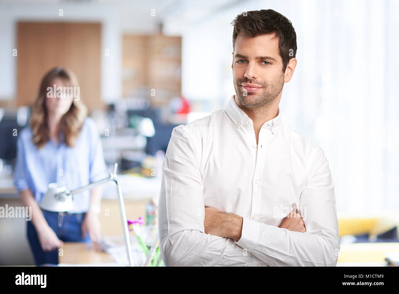 Confident young businessman with arms crossed wearing shirt and looking ...