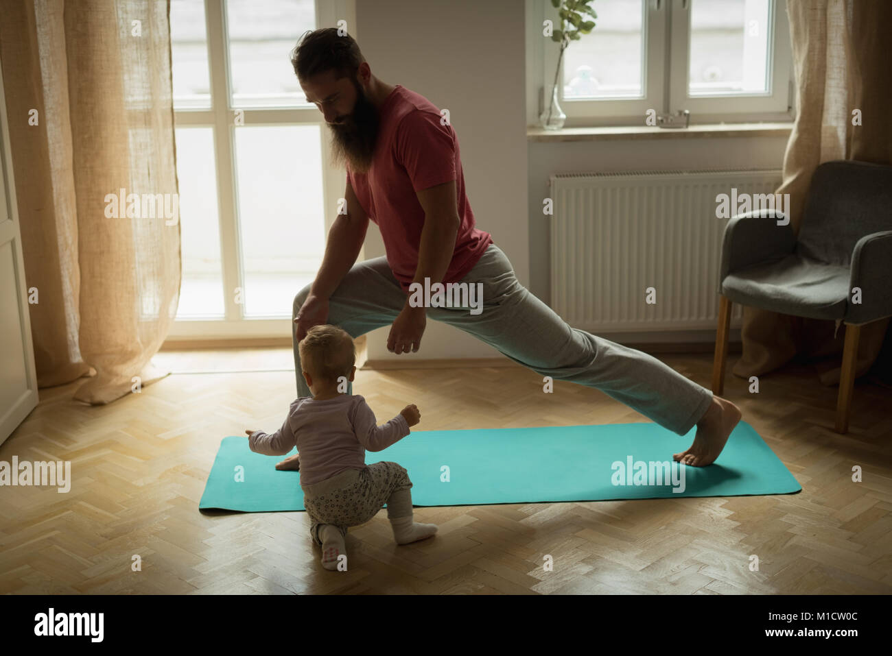 Baby imitating his father while exercising Stock Photo