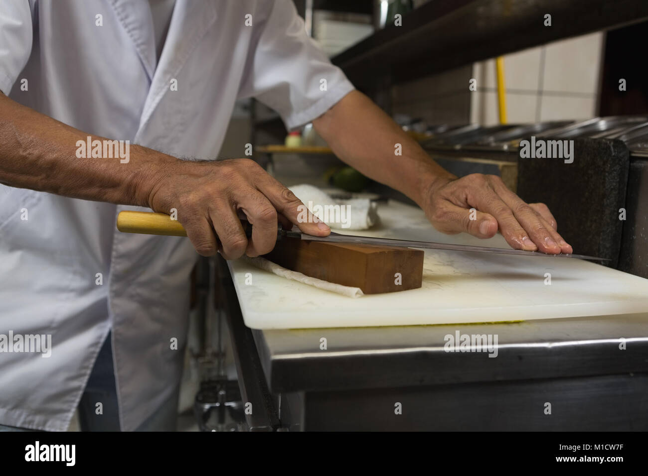 Senior chef holding knife in kitchen Stock Photo