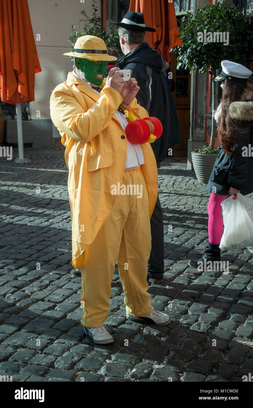 Cologne, Germany - March 14th 2014: A man wears the costume from the movie 'The Mask', a yellow suit with a yellow hat and green face Stock Photo