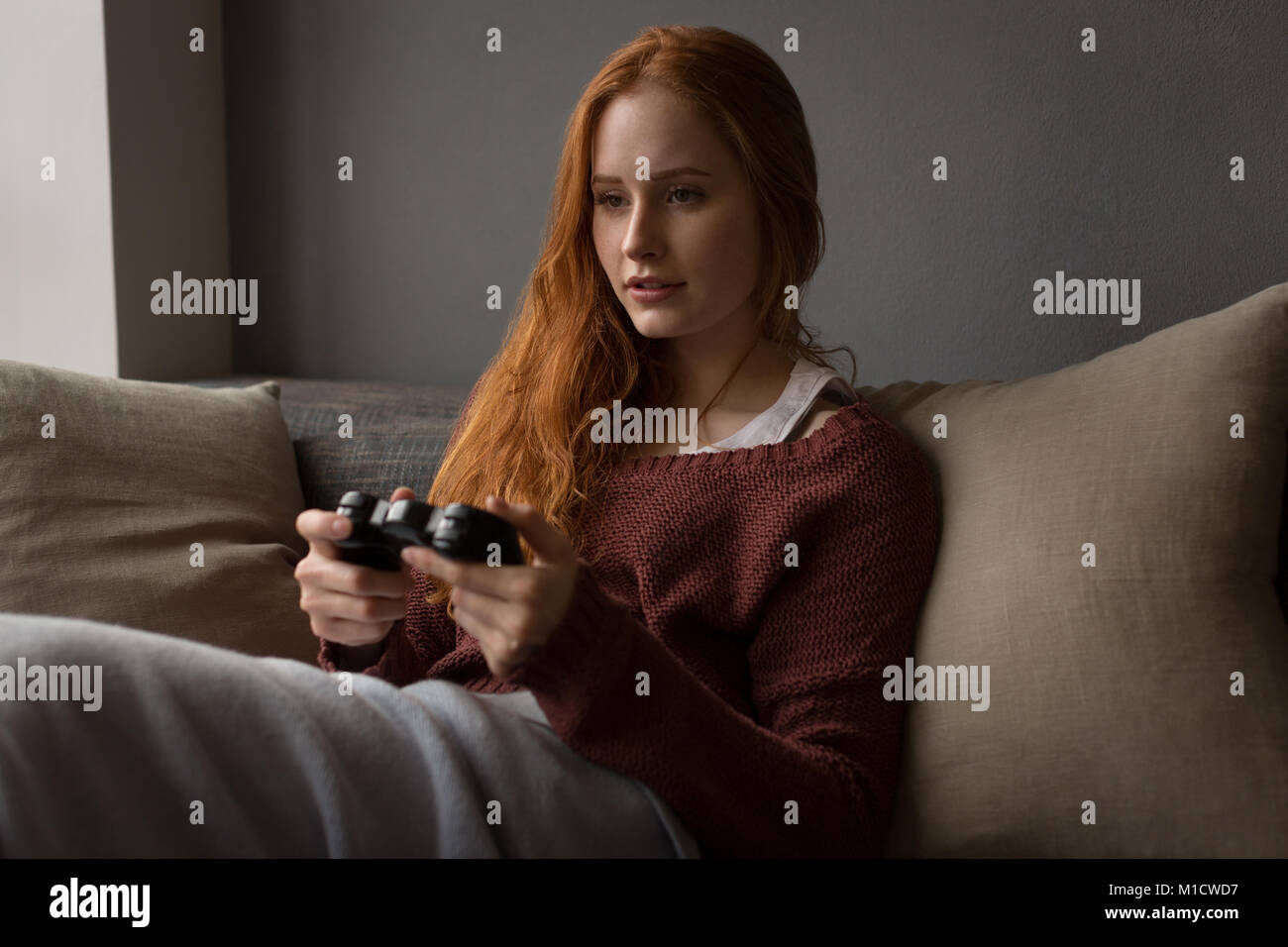 Woman playing video games at home Stock Photo