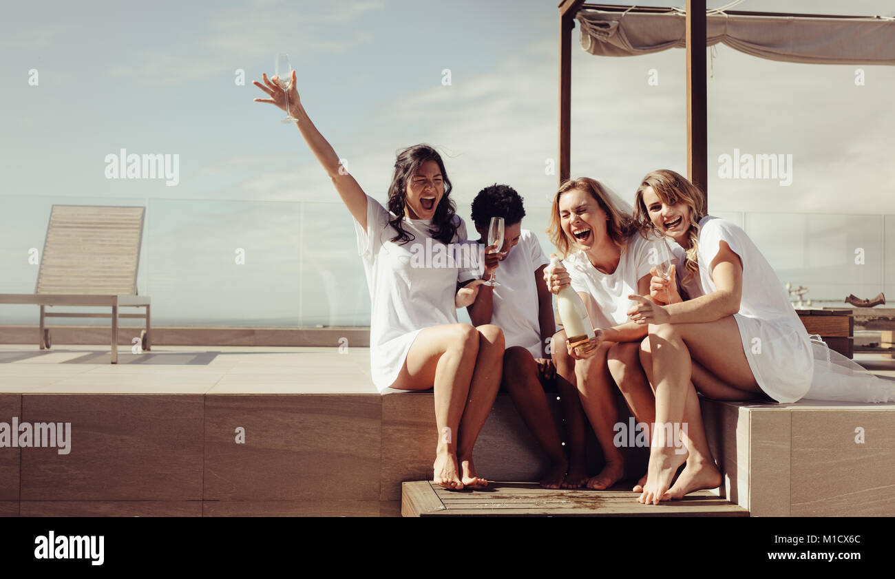 Hen party on the rooftop. Bride and bridesmaids having champagne and laughing. Girls are going crazy before wedding. Stock Photo