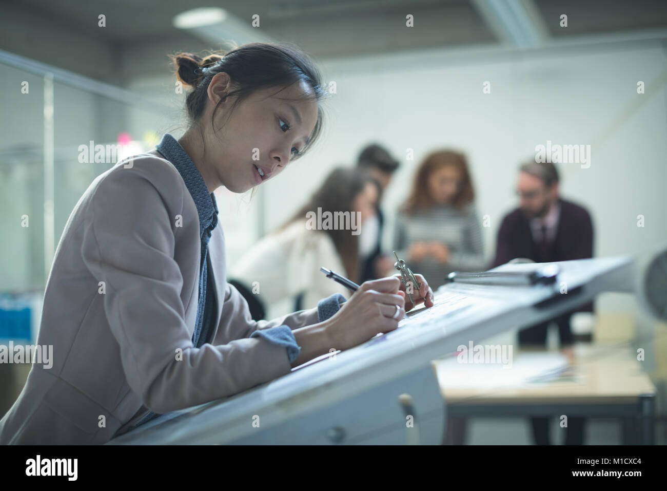 Female executive working over drafting table Stock Photo