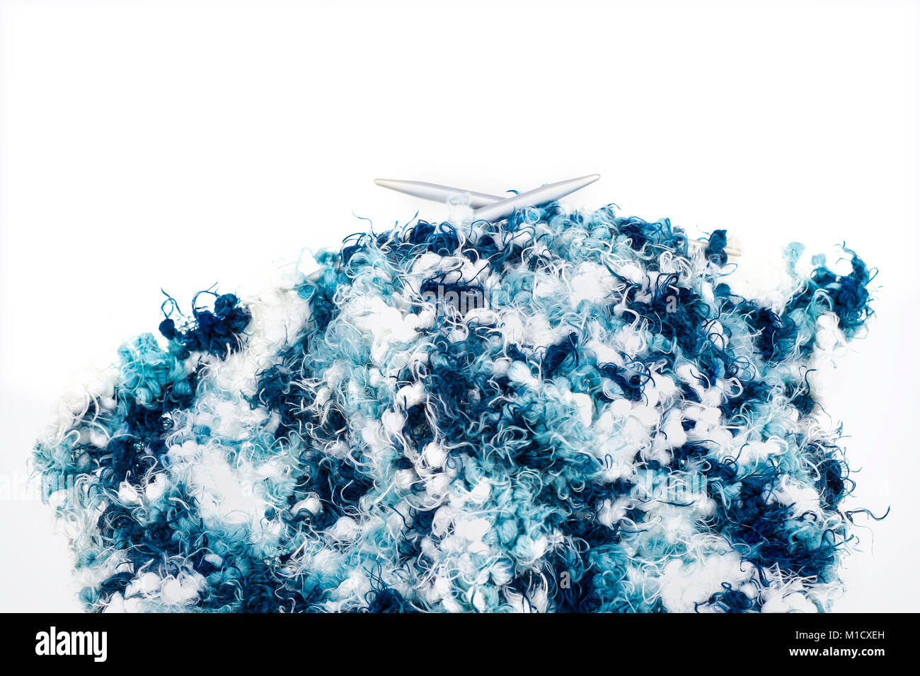 Knitting kit with blue colored, fluffy wool isolated in front of white background Stock Photo