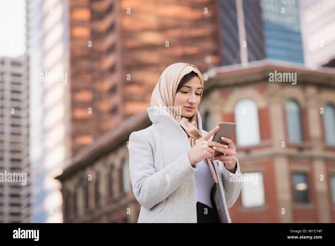 Woman in hijab using mobile phone Stock Photo