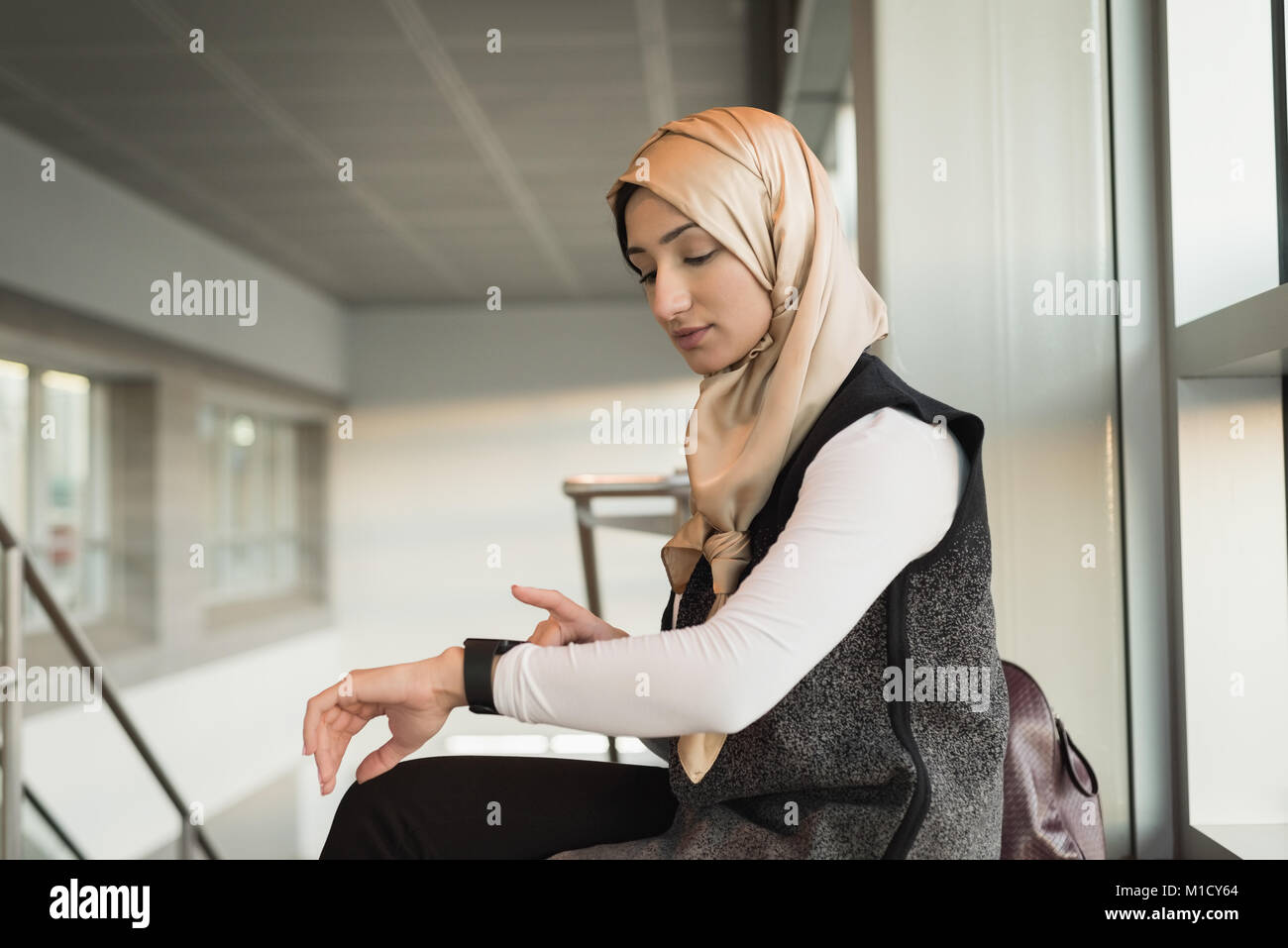 Woman in hijab using smartwatch Stock Photo