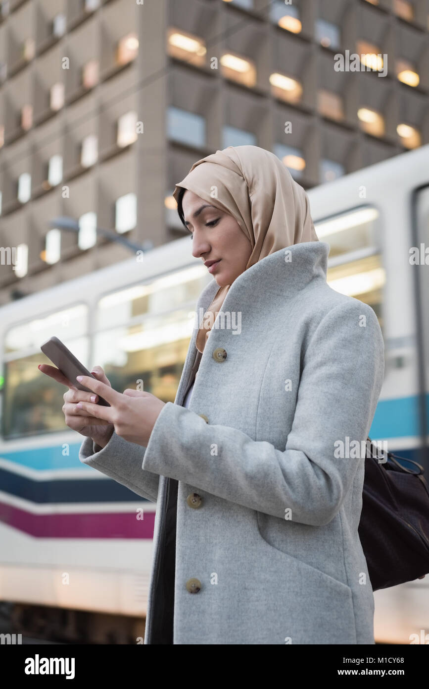 Woman in hijab using mobile phone Stock Photo