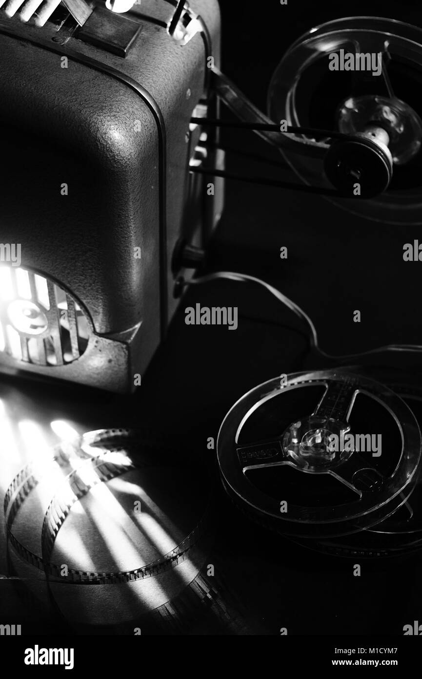 Old film projector and cassettes in the dark Stock Photo