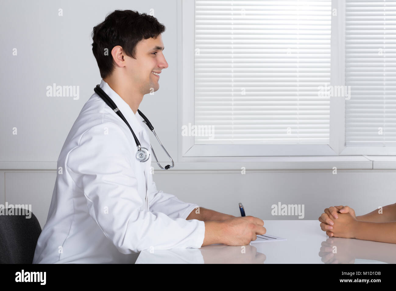 Male Doctor Giving Prescription To Sick Patient In Hospital Stock Photo