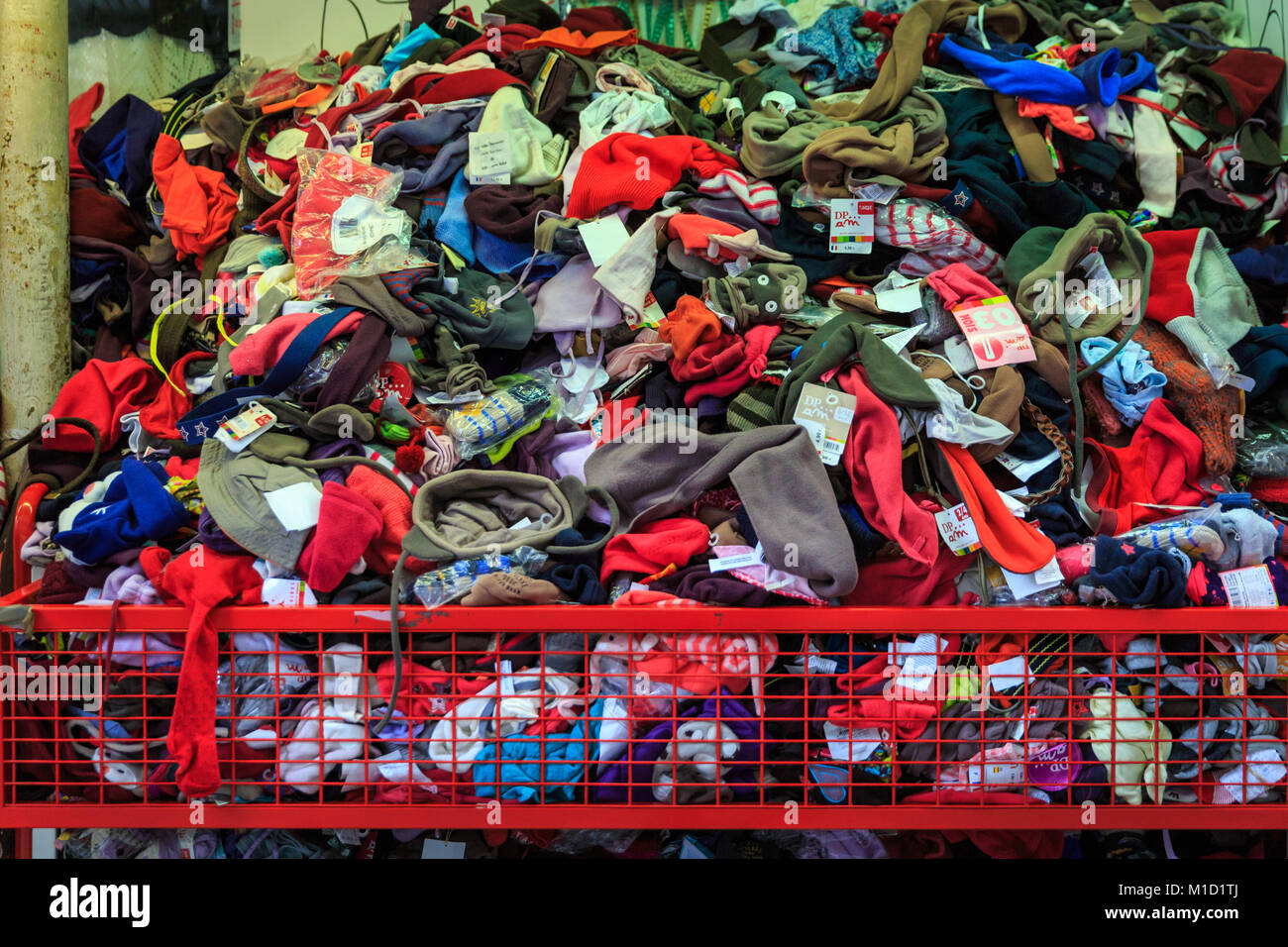 Heap of clothes, garments and accessories in a pile for bargain shopping, shop front exterior, France Stock Photo