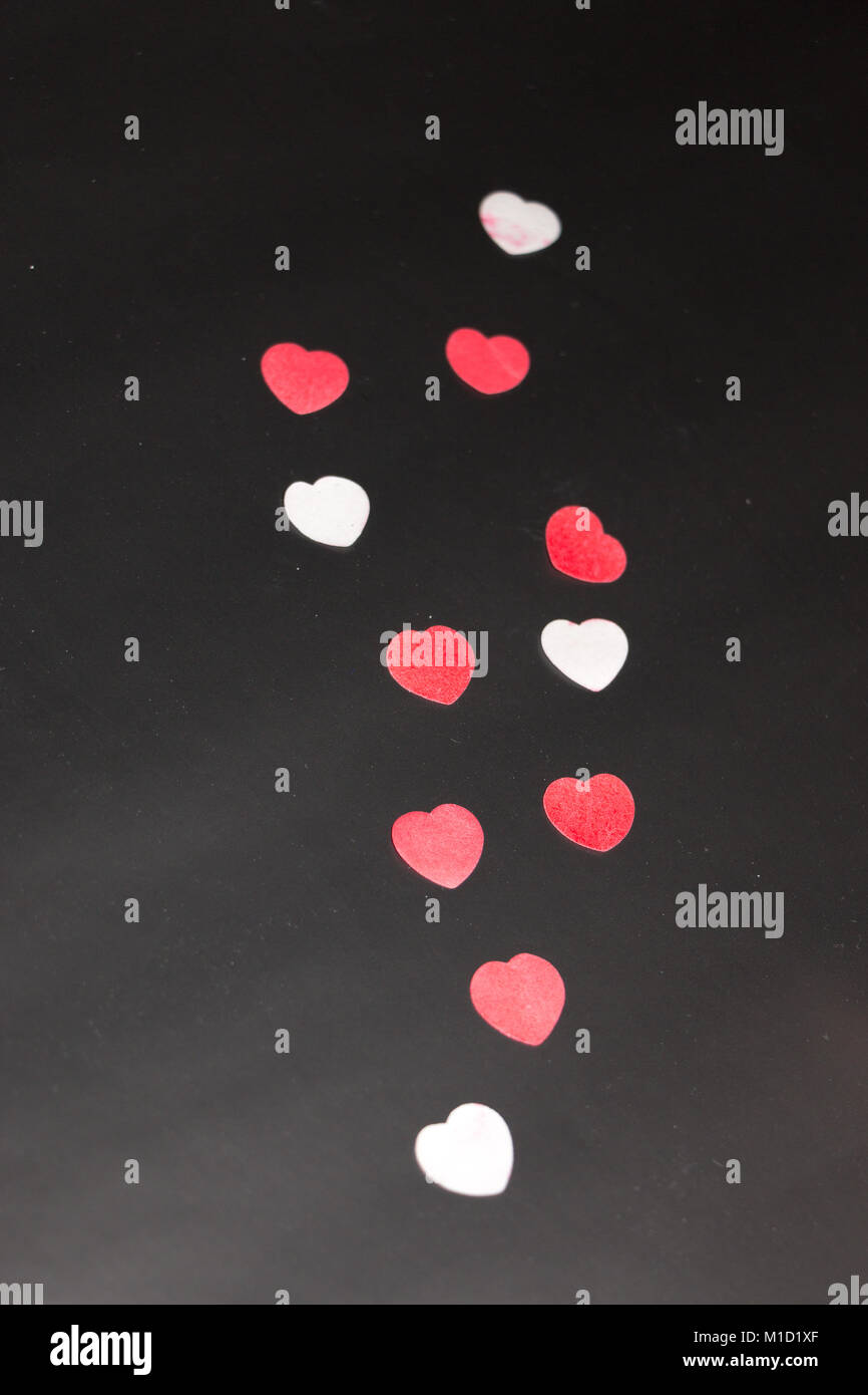 red and white hearts on a black background Stock Photo - Alamy