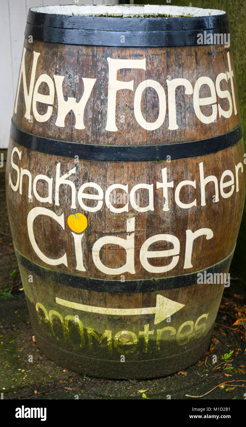 Disused wooden cider barrel now being used as a direction signpost in Burley, New Forest, UK Stock Photo