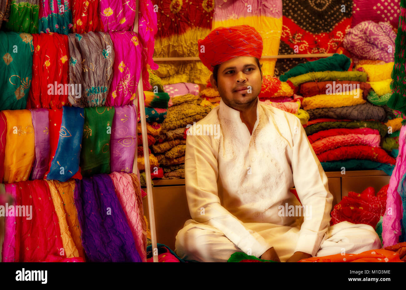 Young Rajasthani male wearing traditional dress selling Rajasthan dress materials at Mehrangarh Fort, Jodhpur Rajasthan India. Stock Photo