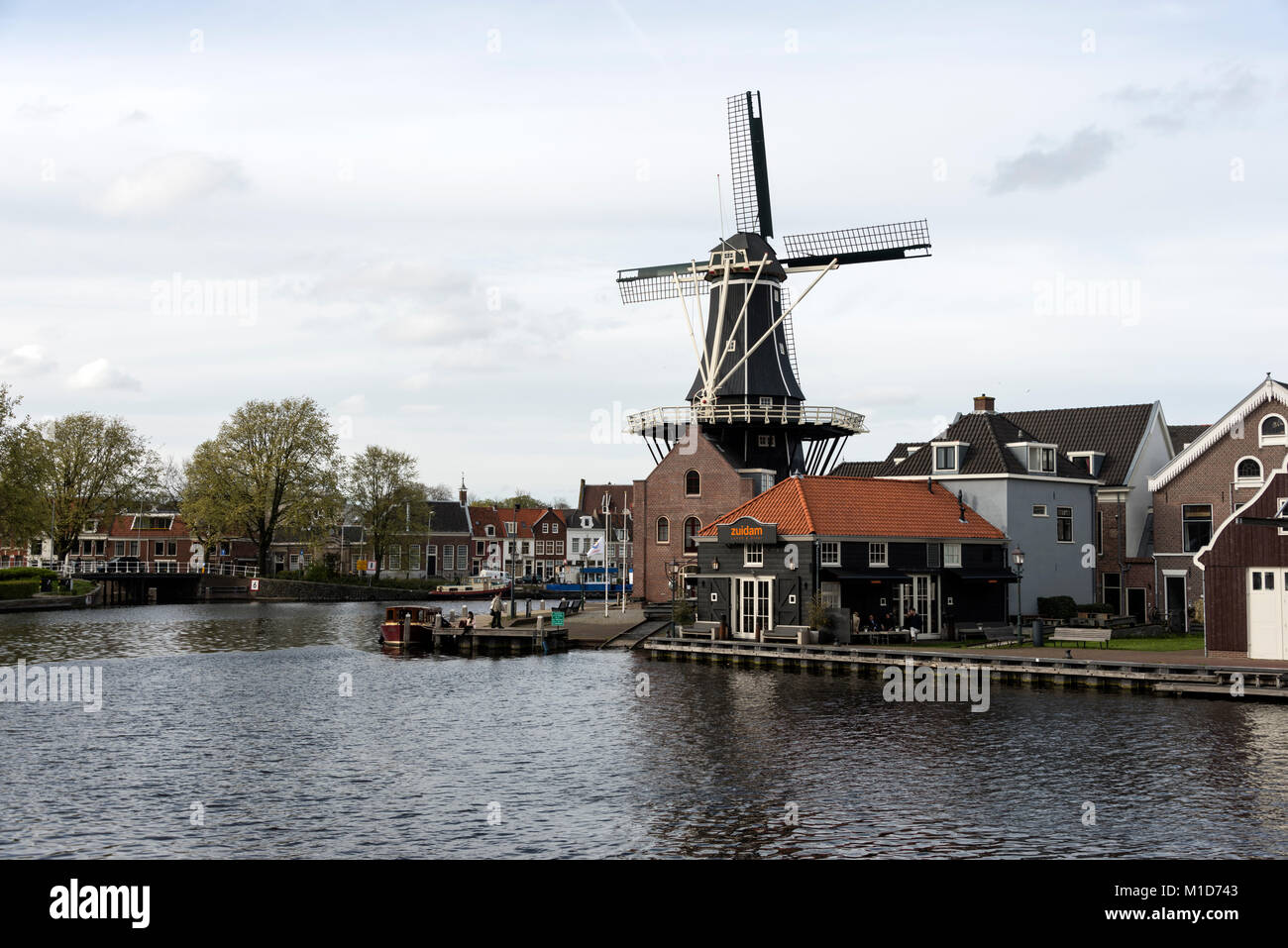 On the bend of the Spaarne River that cuts its way through the centre of Haarlem is one of Haarlem’s most recognised landmarks, the Molen de Adriaan w Stock Photo