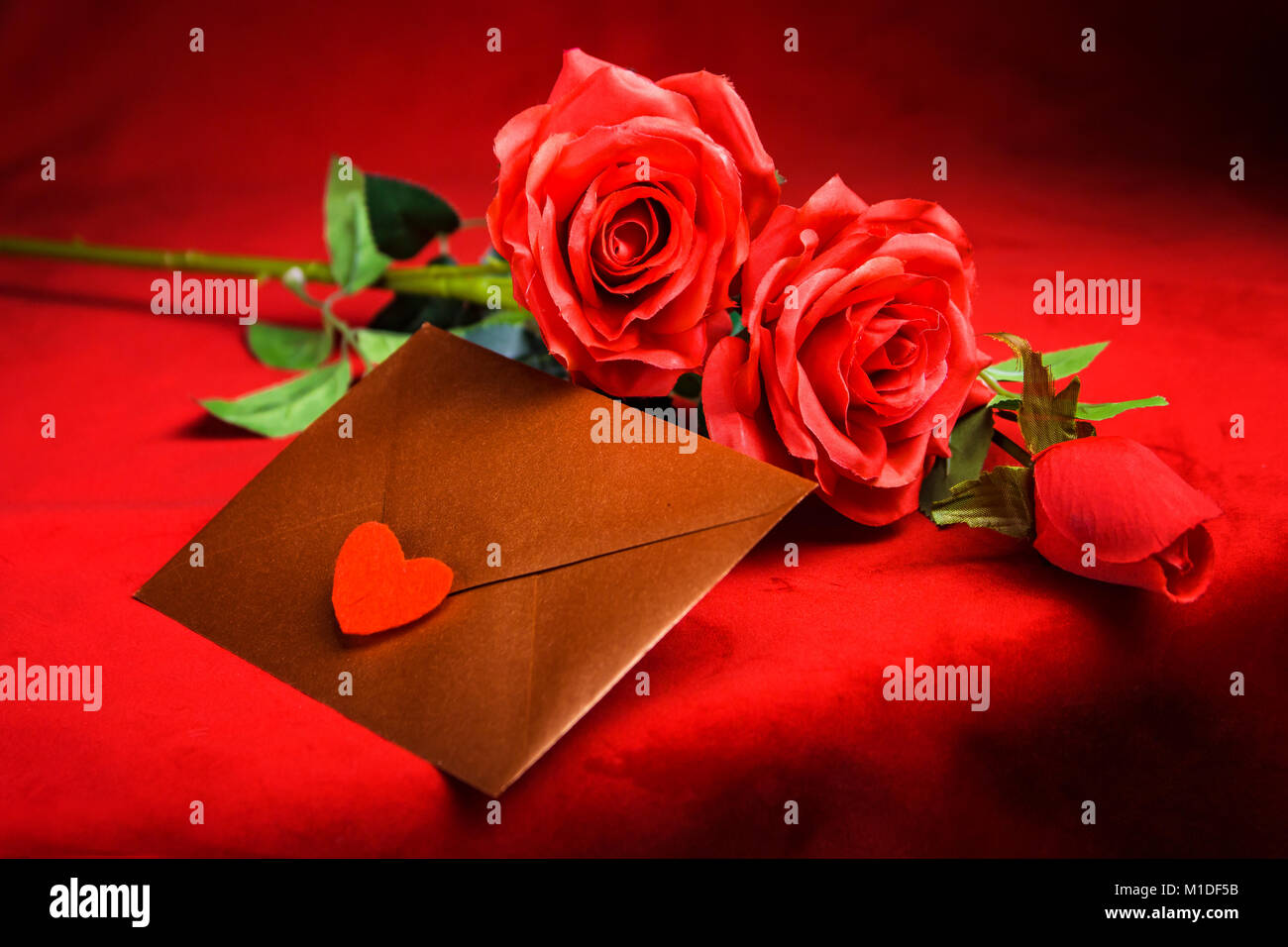 Valentine concept, love letter, rose and a heart cup on a red background Stock Photo
