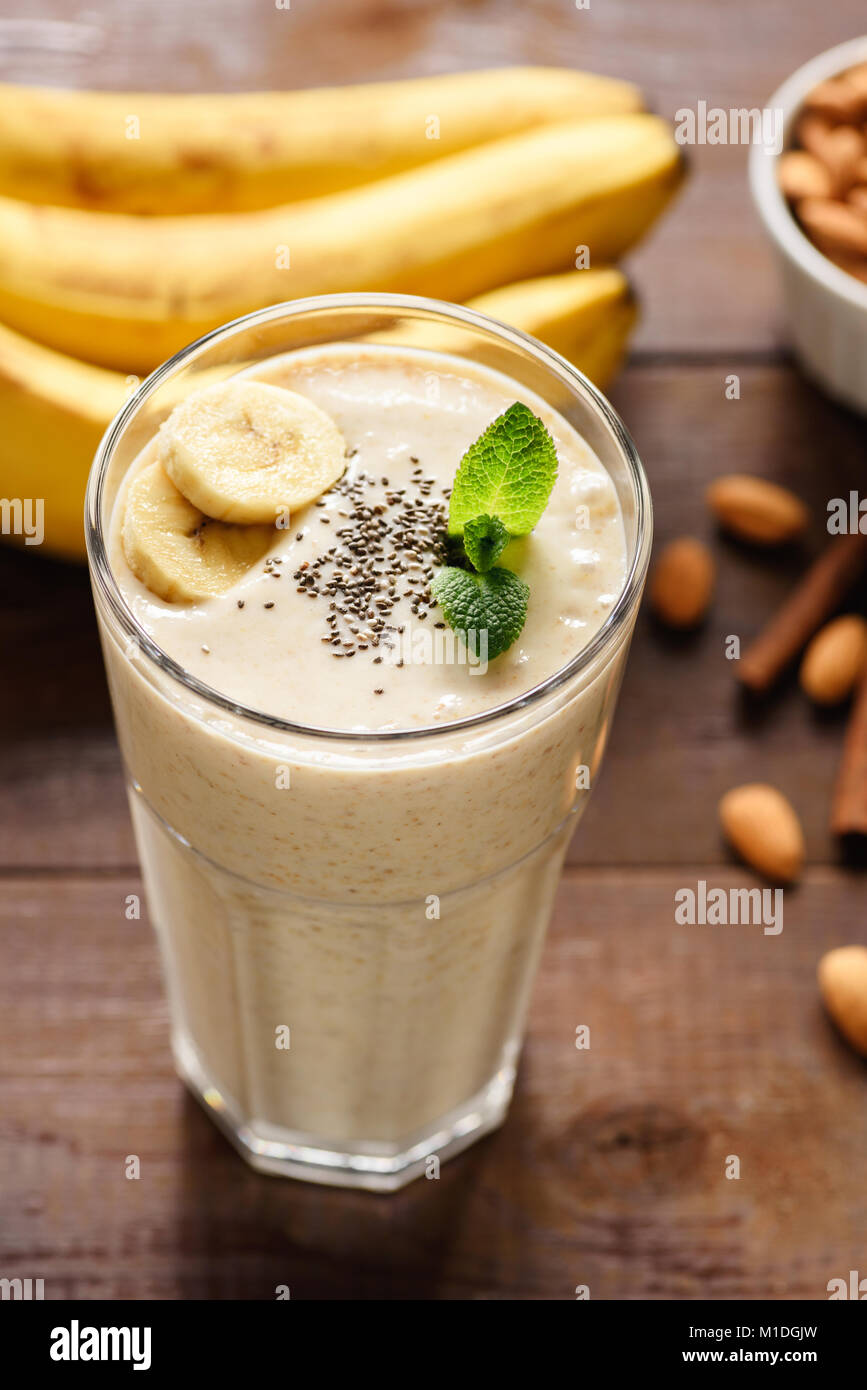 Banana smoothie or milkshake with chia seeds in a glass. Top view ...