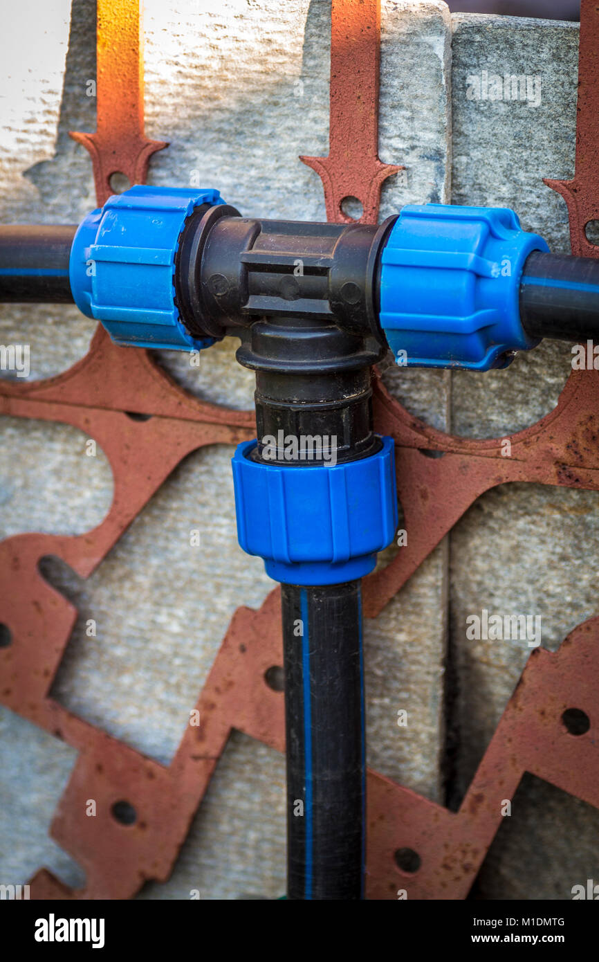 Connecting plastic irrigation pipes in the backyard of a private house