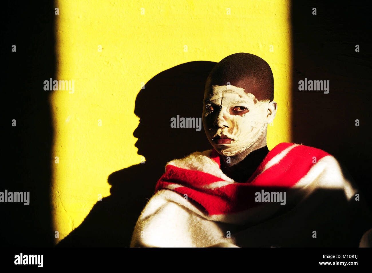 2014-06-20. Initiates are seen smeared with white clay on their face, covered in red and white blanket. during a initiation ritual. Stock Photo