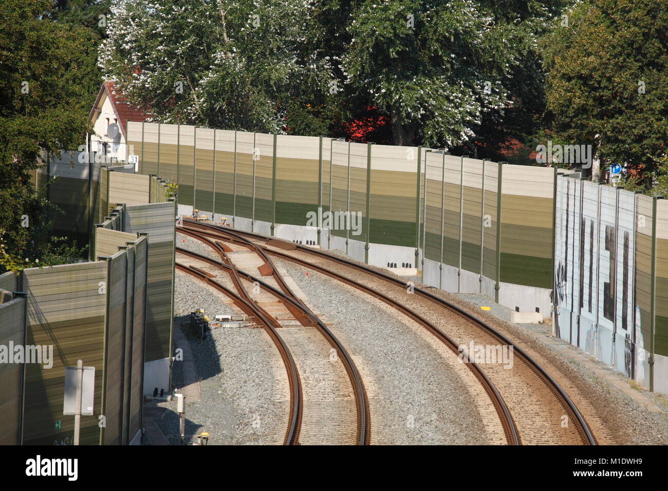 Railroad tracks with noise barrier, Varel, Lower Saxony, Germany, Europe  I Eisenbahnschienen mit Lärmschutzwall, Varel, Niedersachsen, Deutschland, E Stock Photo