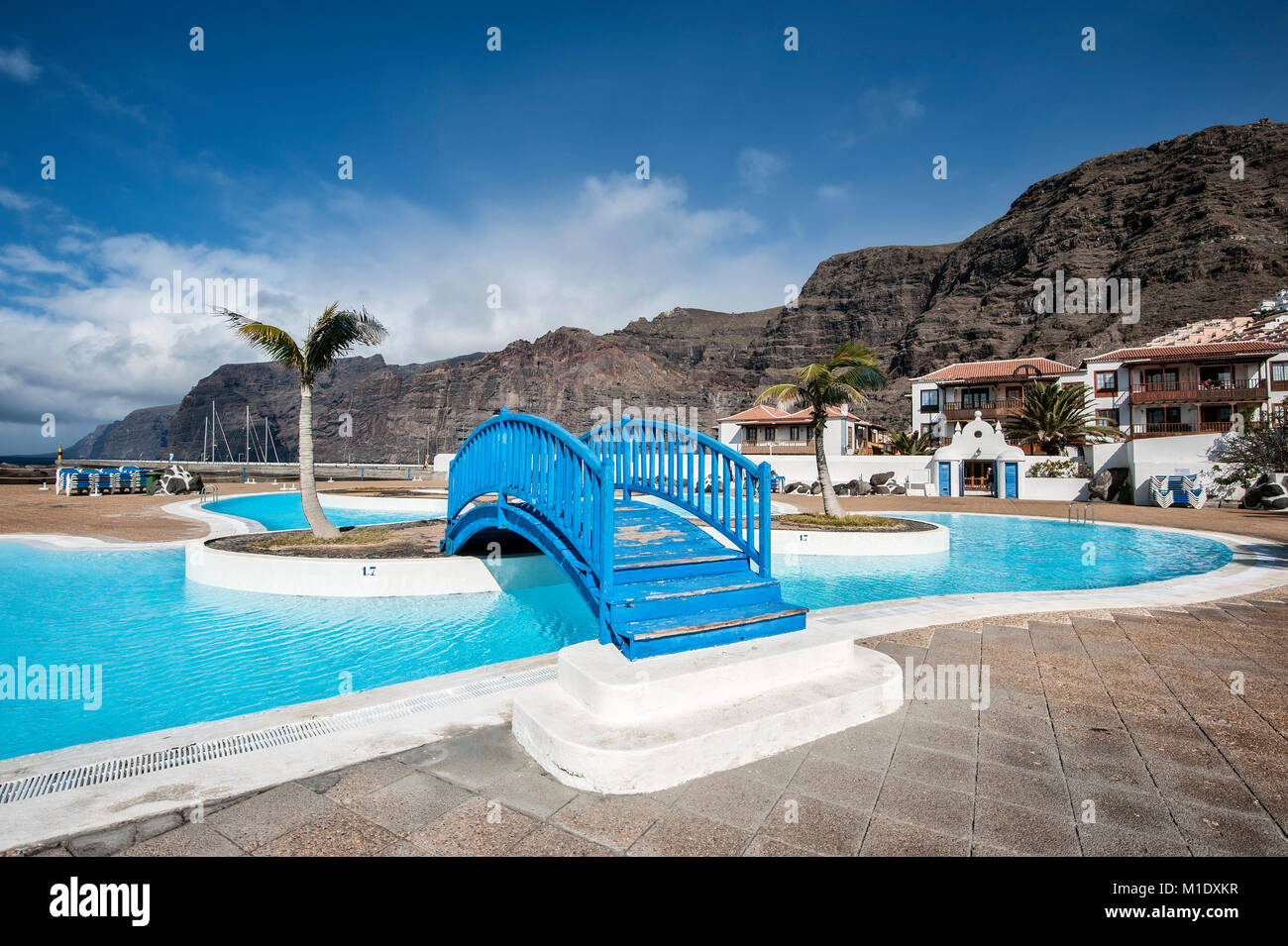 Swimming pool at the port of Los Gigantes with Masca Mountains in the background. Stock Photo