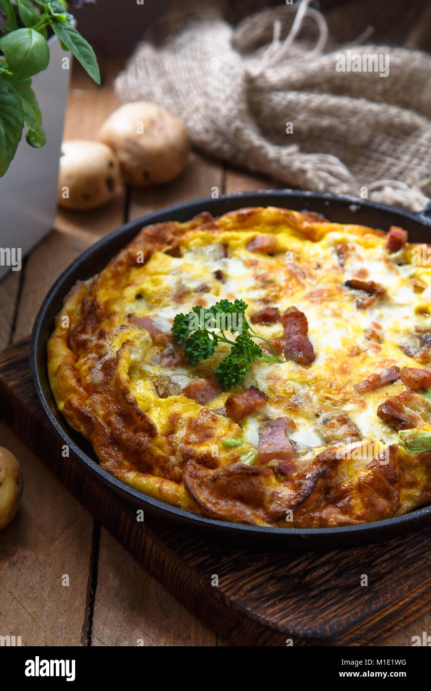 Baked omelette with bacon and cheese in a pan, close view Stock Photo