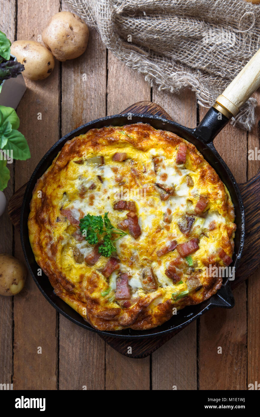 Homemade breakfast with delicious omelette filed with ham, potato and cheese, top view Stock Photo