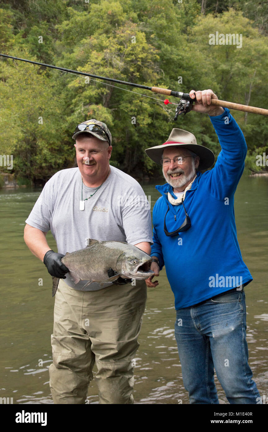 Fishing guide Jeff Gear and outdoor writer Terry Sheely with a fresh caught Chinook salmon on the Klickitat River, in Washington State. Stock Photo