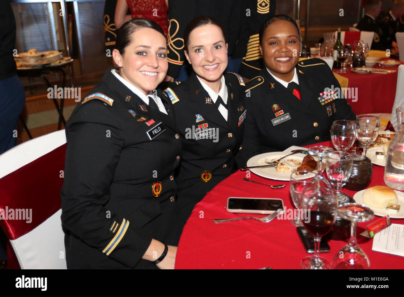 From left to right Capt. Carly A. Field, Headquarters and Headquarters Battery, 35th Air Defense Artillery Brigade, assistant officer in charge of the Saint Barbara’s Ball, Capt. Paulina D. Reilly, HHB, 35th ADA Brigade S2 assistant and Master Sgt. Latrice R. Barker-Williams, HHB, 35th ADA Brigade S2 noncommissioned officer in charge, smile for a quick Stock Photo