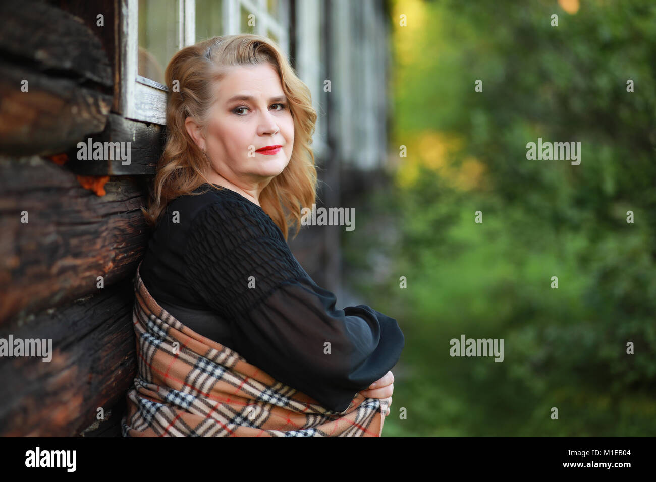 An elderly woman on the porch of a house Stock Photo - Alamy