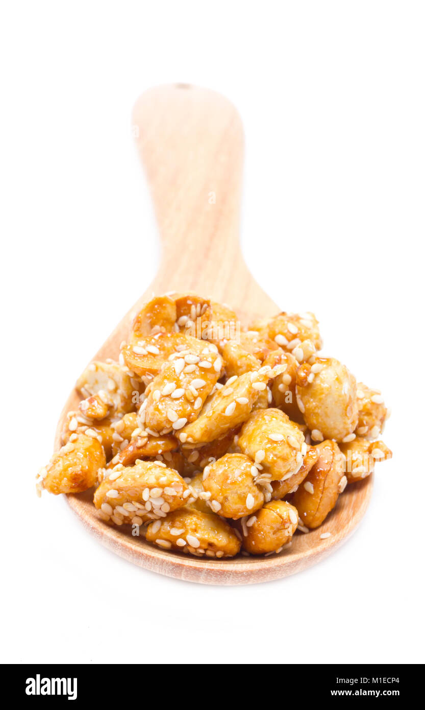 Crispy sugared nuts with wooden spoon isolated on white Stock Photo Alamy