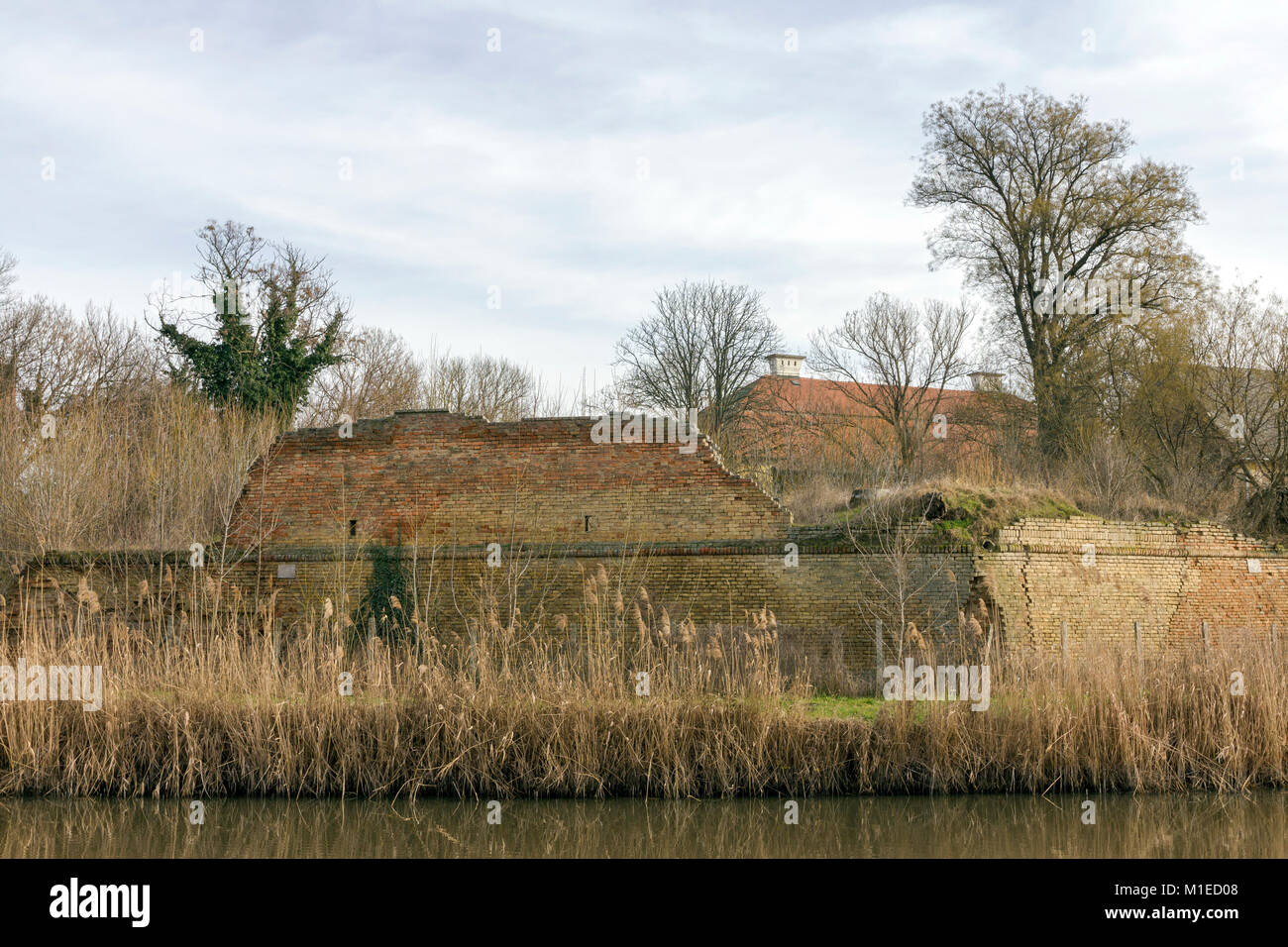 Ruined wall of the baroque fort with the Kurca river foreground in Szegvar, Hungary Stock Photo
