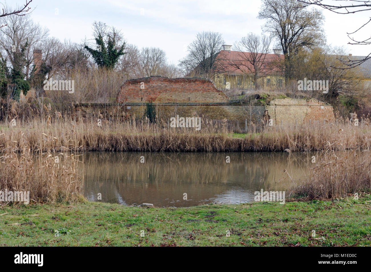 Ruined wall of the baroque fort with the Kurca river foreground in Szegvar, Hungary Stock Photo