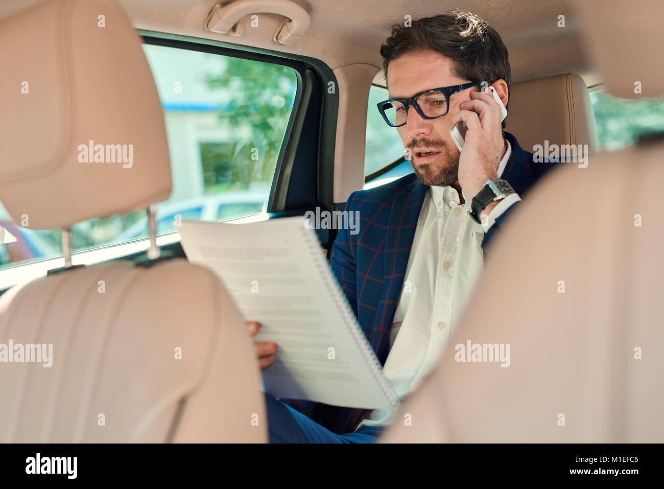 Successful businessman working in the backseat of a car  Stock Photo