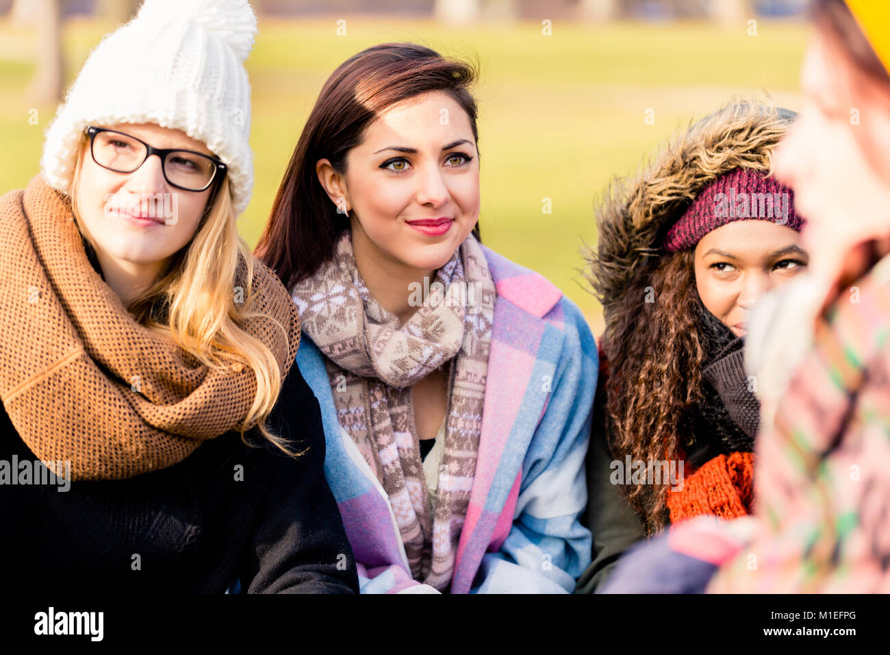 Young women daydreaming while sharing ideas outdoors Stock Photo
