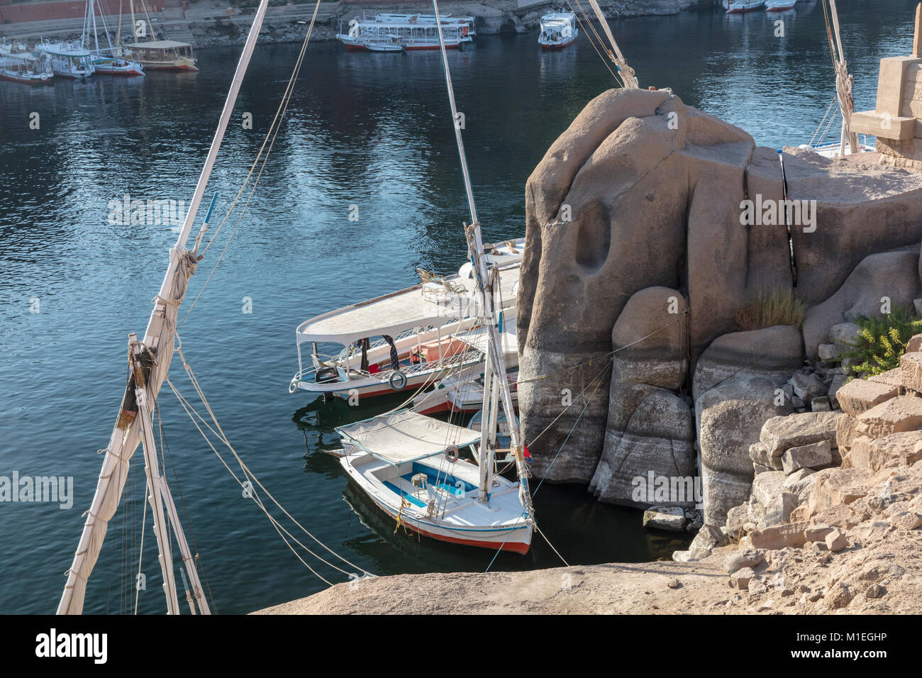 Excursion boats and rock formation that gives its name to Elephantine Island, Aswan, Egypt Stock Photo