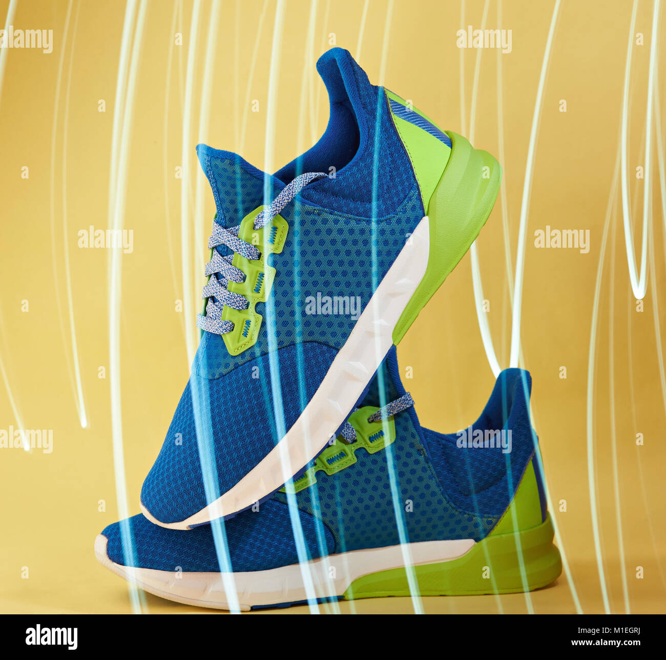 Blue pair of sneakers shoes on yellow background with illumination effect Stock Photo