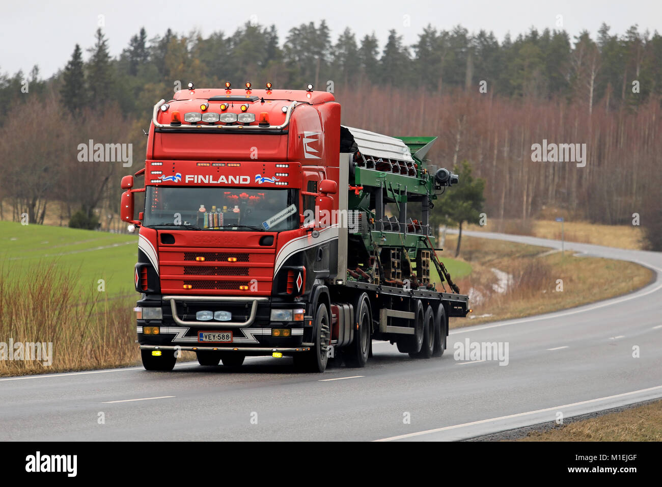 SALO, FINLAND - JANUARY 26, 2018: Customized 4-series Scania truck hauls machinery along rural highway in South of Finland. Stock Photo