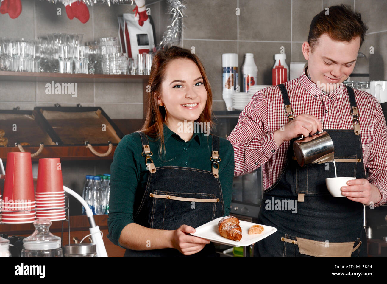 Couple of barista are working in cafe. Handsome man and attractive woman are making coffee. Food and drink industry concept Stock Photo