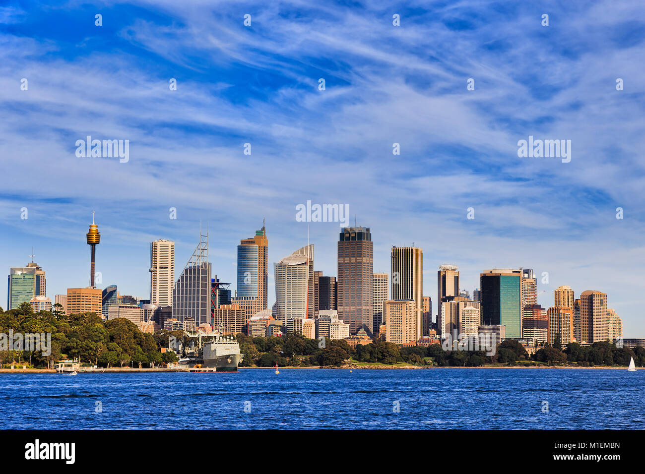Sydney city CBD high-rise towers rising above blue waters of harbour on a sunny bright day under blue sky. Stock Photo