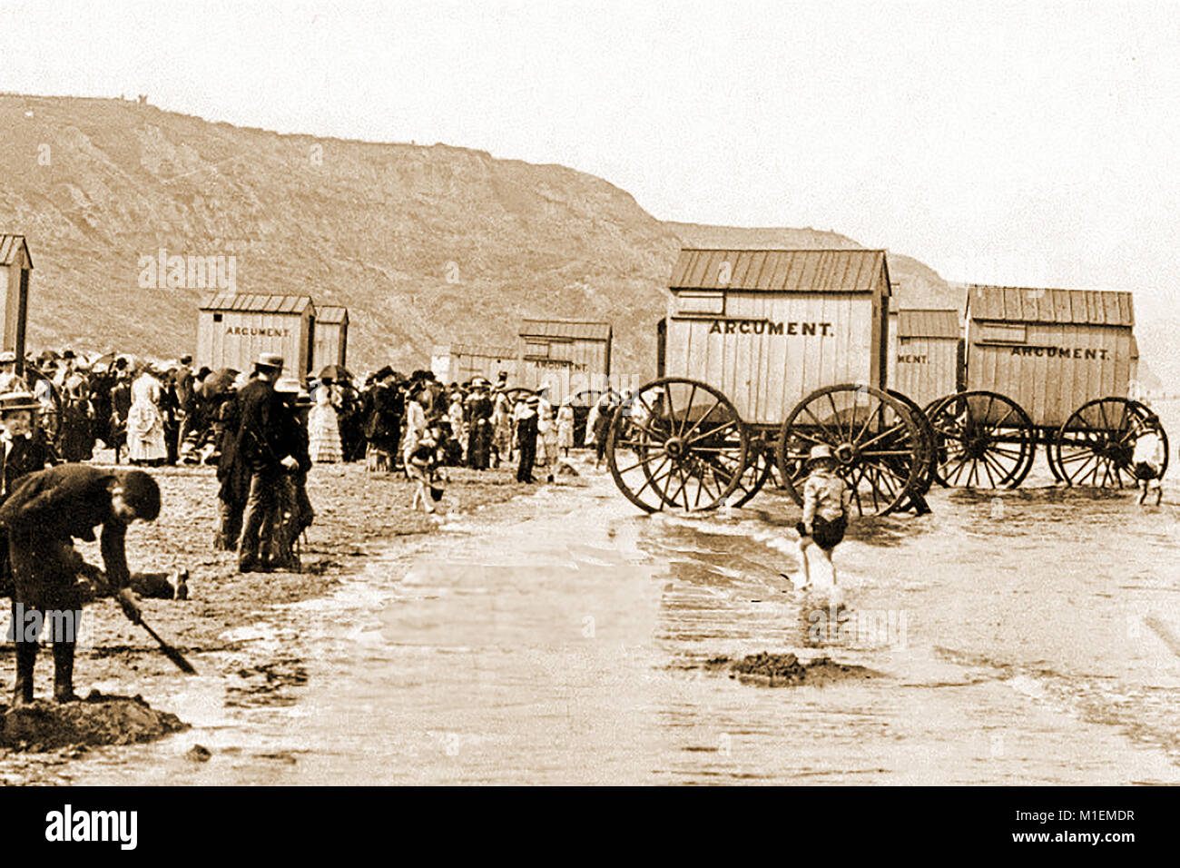 A Victorian photograph showing crowds on the beach and Mr Argument's bathers bathing machines at Whitby, Yorkshire, UK Stock Photo