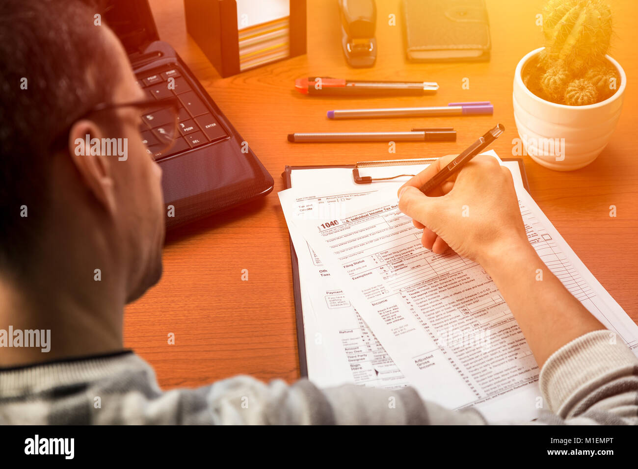 Person completing 1040 tax form Stock Photo