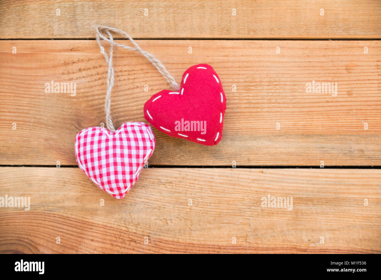 Two red fabric hearts on old wood background Stock Photo - Alamy